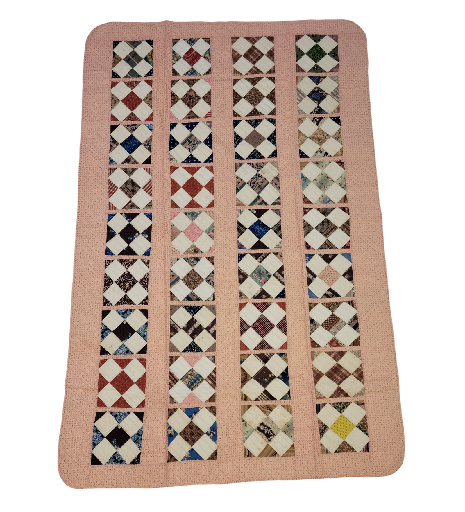 PIECED "HIRED MAN'S" QUILT: American, mid-19th century, cotton. Various printed fabrics in a 9 by 4 grid, the narrow size suggesting a single-size or so-called "hired man's" bedstead. 89" by 57".