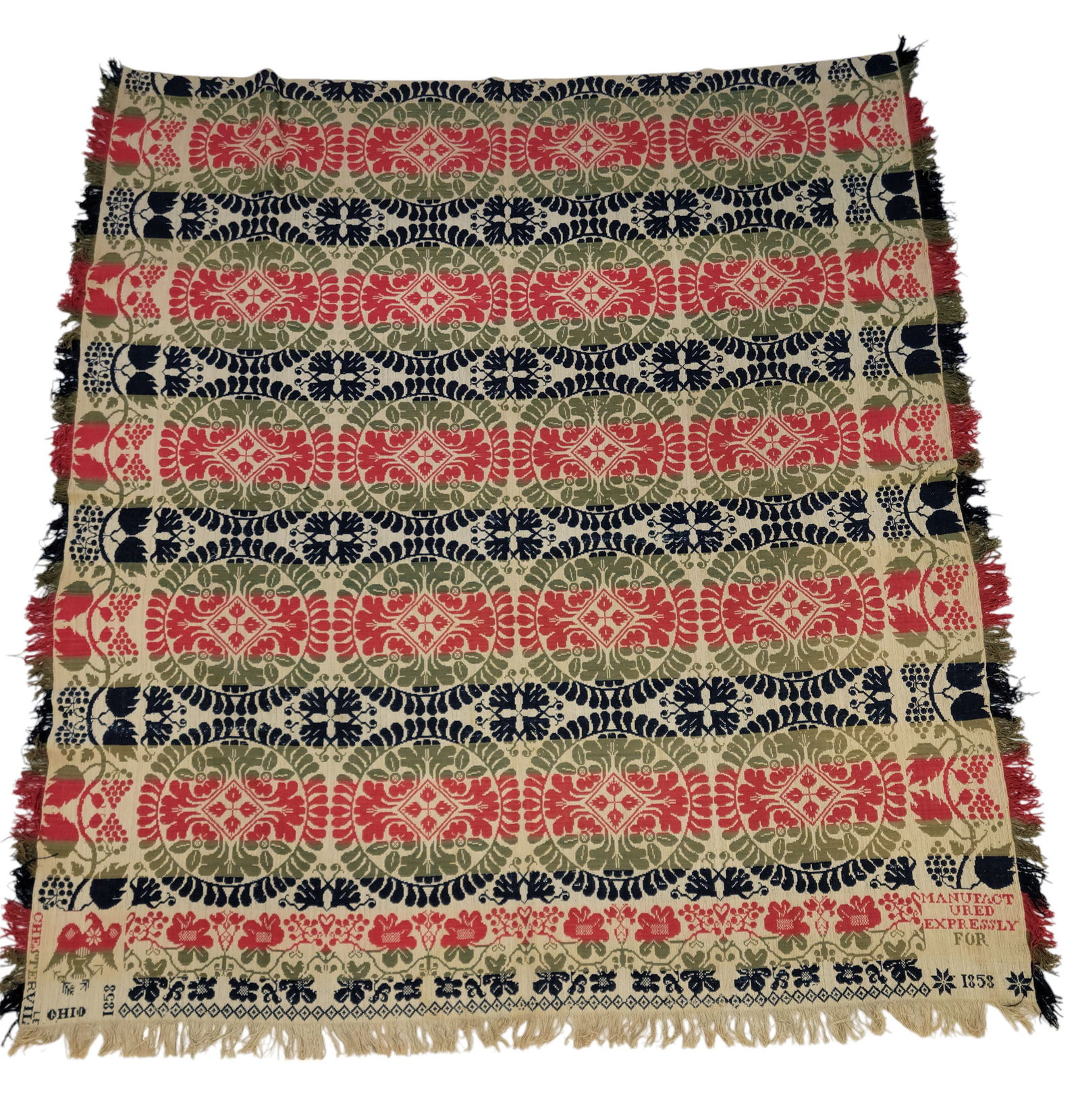 CHESTERVILLE, OHIO COVERLET: Chesterville, Ohio, Morrow County, 1858. Red, green and blue, full loom width, with centerfield of laurel wreaths surrounding floral medallions, the longs sides with grapevine borders, a floral foot b