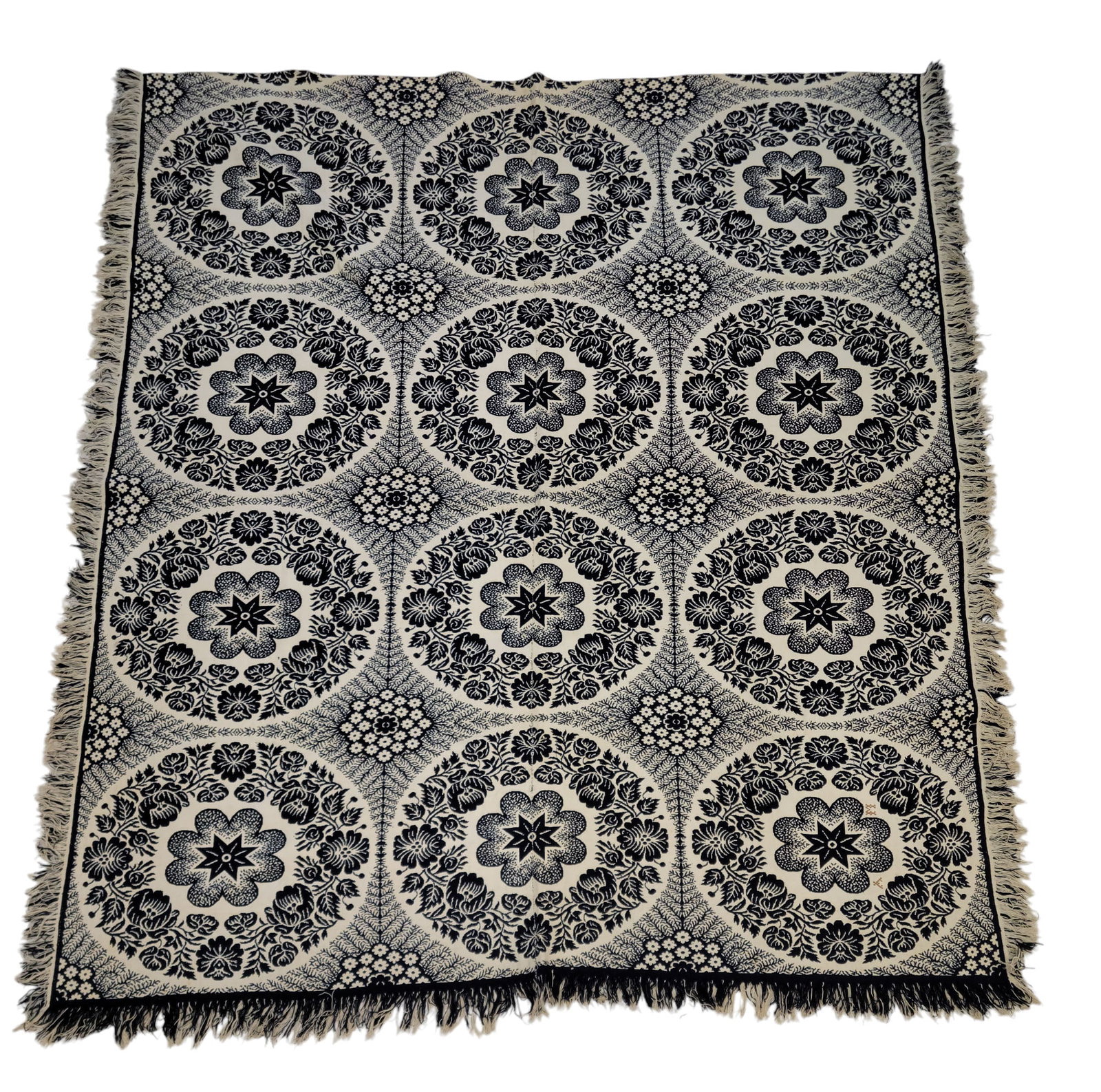 POSSIBLY WAYNE COUNTY, OHIO COVERLET: Mid-19th century. Dark blue, black, and white doubleweave jacquard coverlet with rose wreaths and a star pattern, initials "AM" are included in one medallion, 88" by 78". This coverlet is unsigned, bu