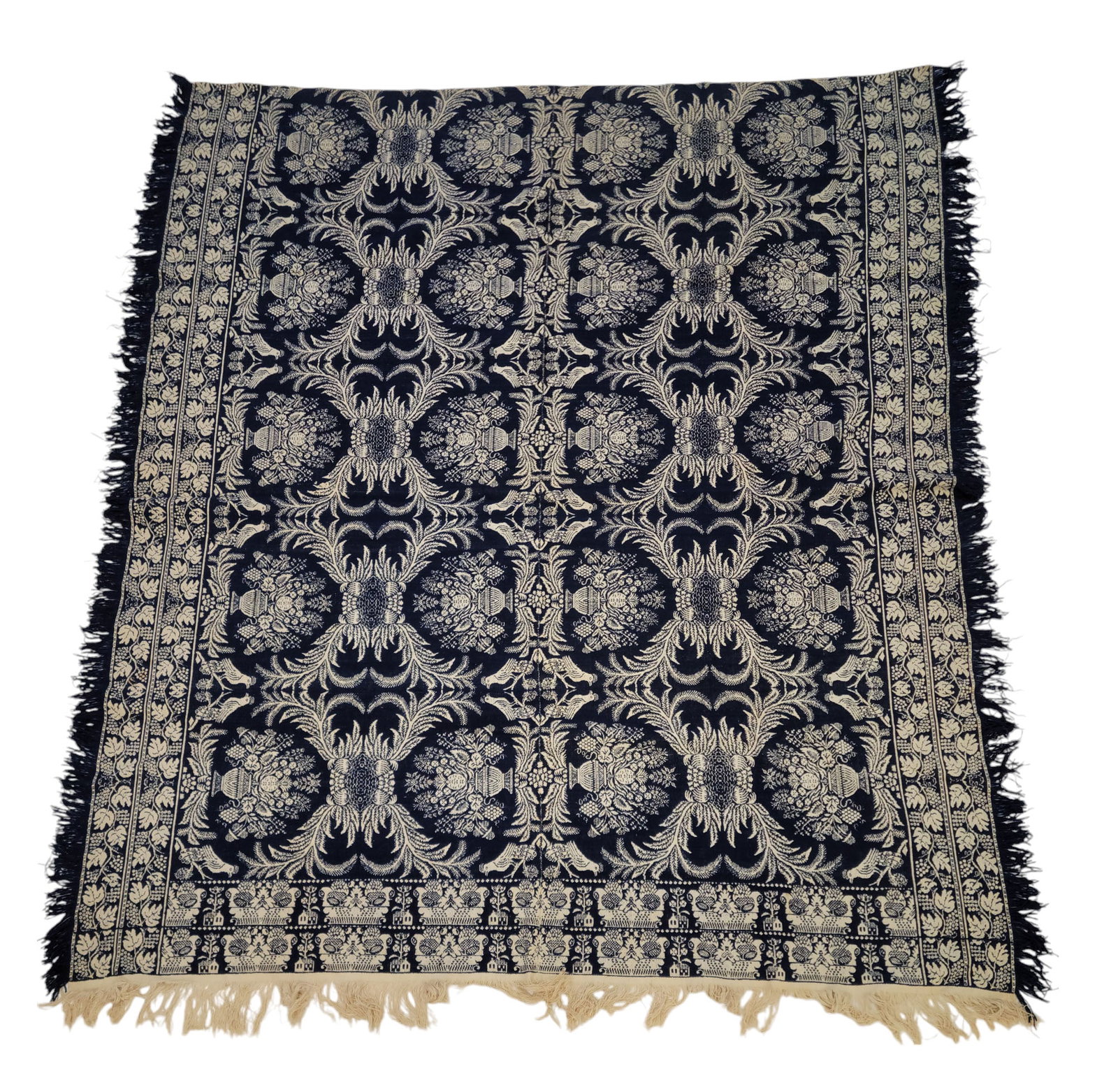 JACQUARD COVERLET: American, mid-19th century. Two piece coverlet with blue and white centerfield of urns with flowers and birds, double side borders of meandering grapevines, and double foot border of flower baskets an