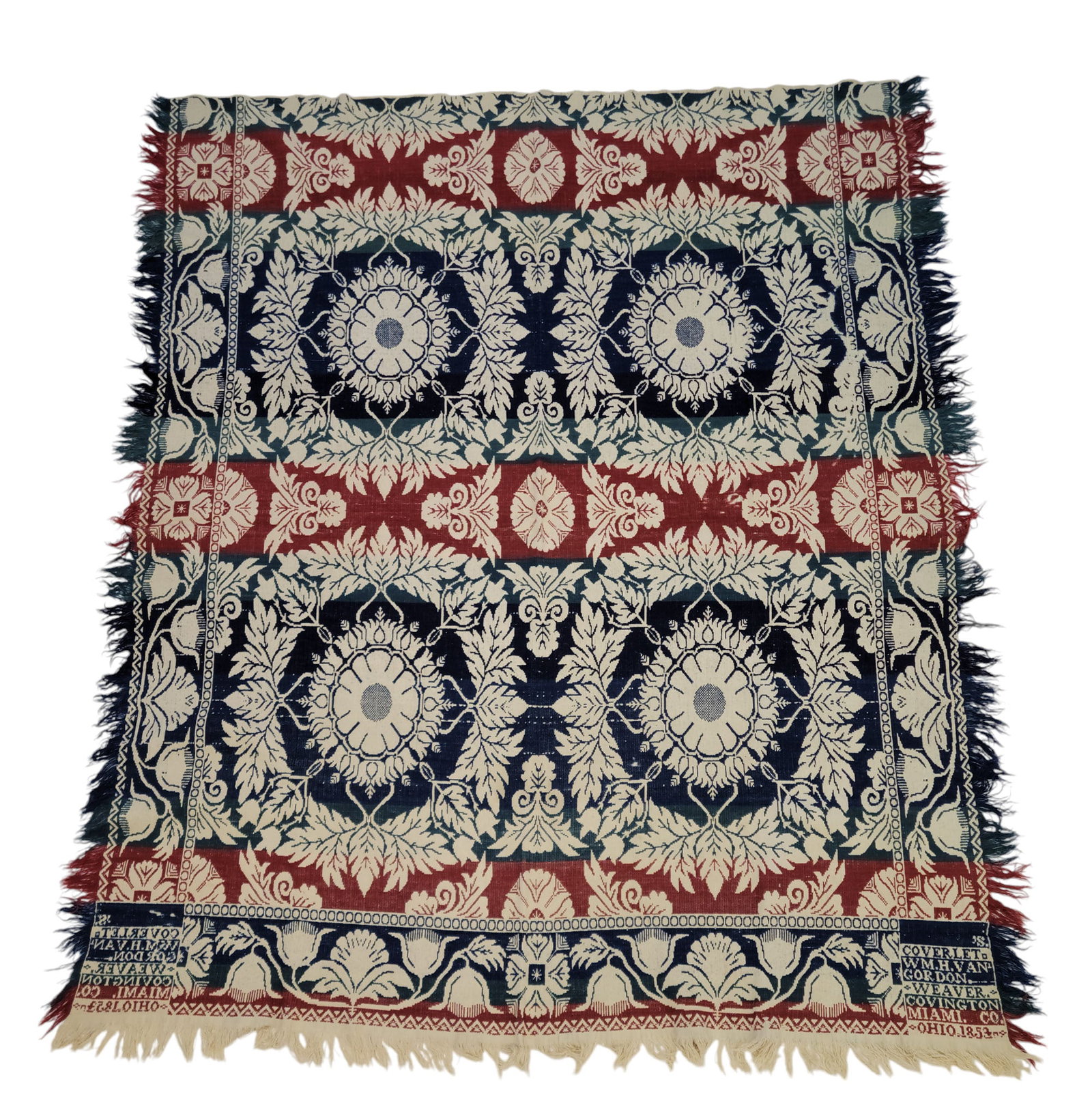 MIAMI COUNTY, OHIO COVERLET: William H. Van Gordon, Covington, Ohio, 1853. A coverlet in blue, green, and red with large floral medallions encircled by leafy wreaths on the interior and vining floral borders, corner block signed 