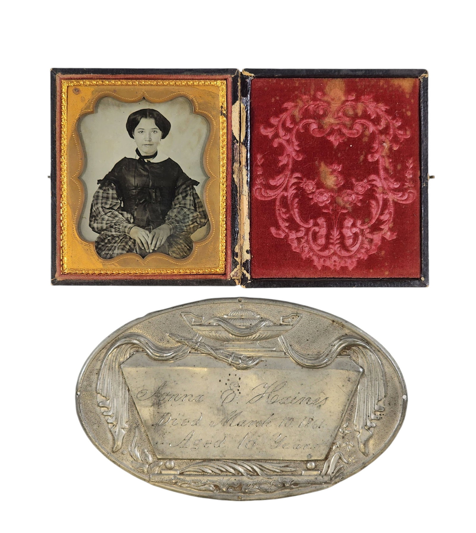 SIXTH PLATE AMBROTYPE OF A YOUNG LADY: Mid-19th century. Seated portrait of a lady wearing a plaid dress. Accompanied by an engraved memorial plaque identifying her as Anna E. Haines. In a pressed leather case.Genealogical research has fou
