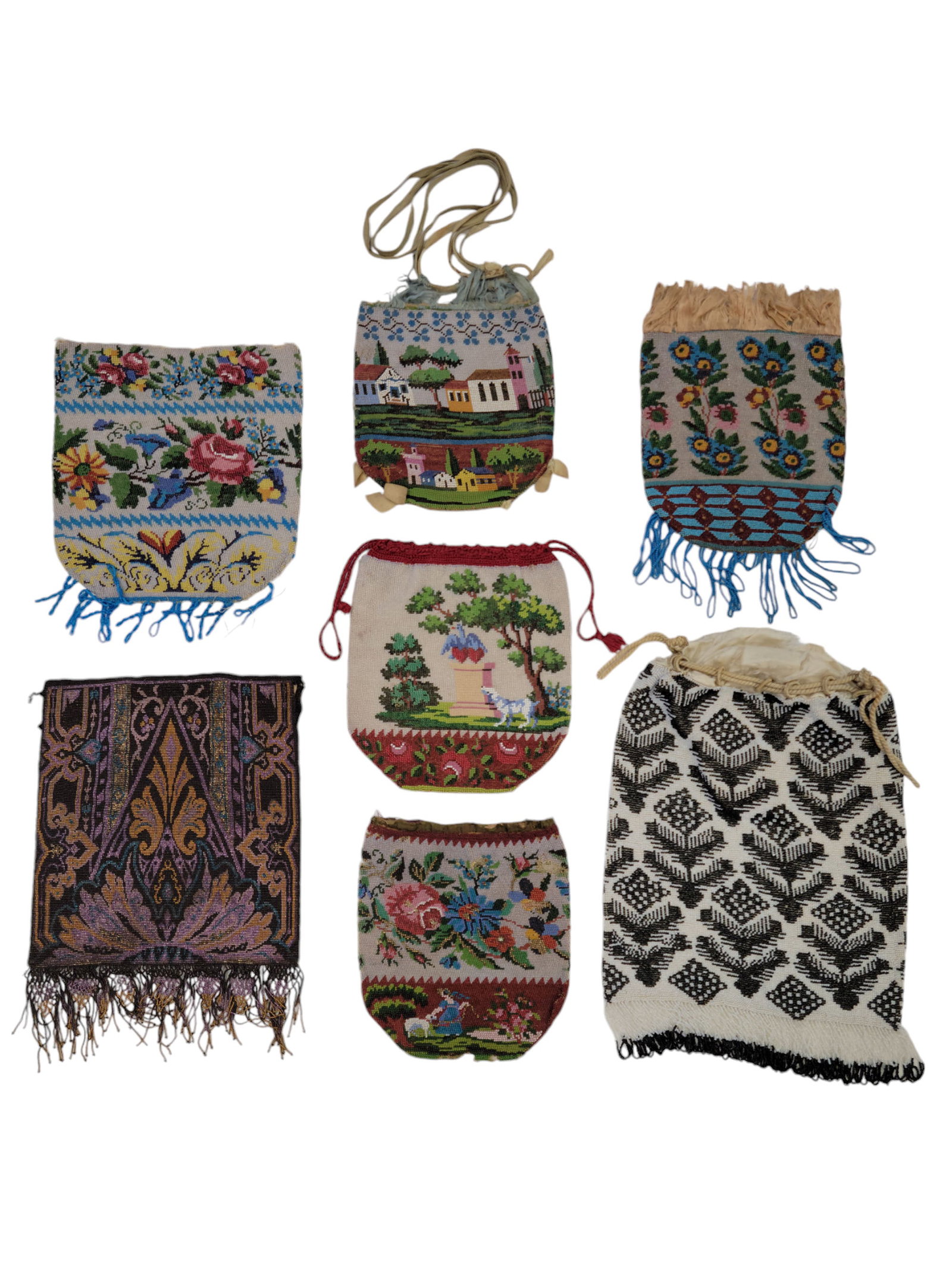 SEVEN VINTAGE BEADED PURSES: Early 20th century. Includes five with floral or figural decoration, two with abstract decoration. The largest is 9" high (excluding fringe).