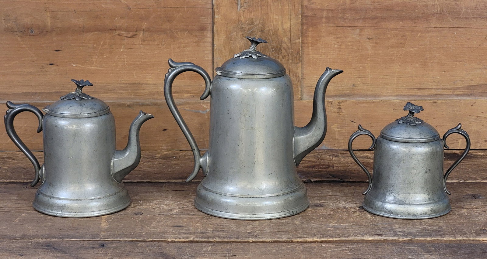 THREE-PIECE CINCINNATI PEWTER COFFEE AND TEA SET: Homan and Co., 3rd quarter-19th century. With floral finials. Coffee pot is 10" high. Provenance: a Gallipolis, Ohio collection.