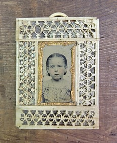 TINTYPE OF A CHILD IN A CARVED FRAME