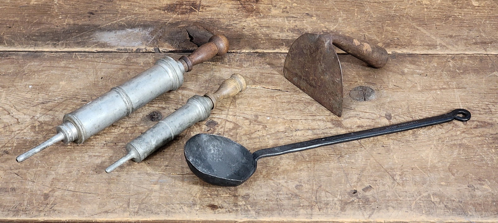 GROUP OF EARLY KITCHEN METAL ITEMS: American, late 19th-early 20th century. Marked iron skimmer, wrought iron dough scraper, and two pewter decorating syringes. Skimmer is 13.5" long. Provenance: private collection.