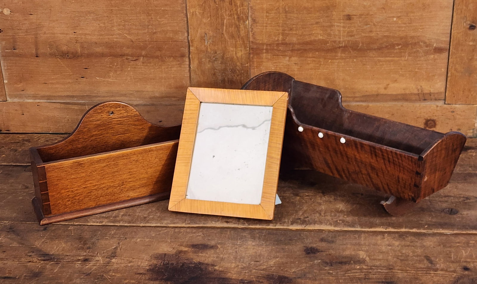 DOLL CRADLE, WALL BOX, & MIRROR: American, 19th century. Includes a curly maple mirror, 10.75" high, 8.75" wide, a curly walnut doll cradle, dovetailed, 18.5" long, and a walnut dovetailed wall box, 14" wide. Provenance: From the Lif
