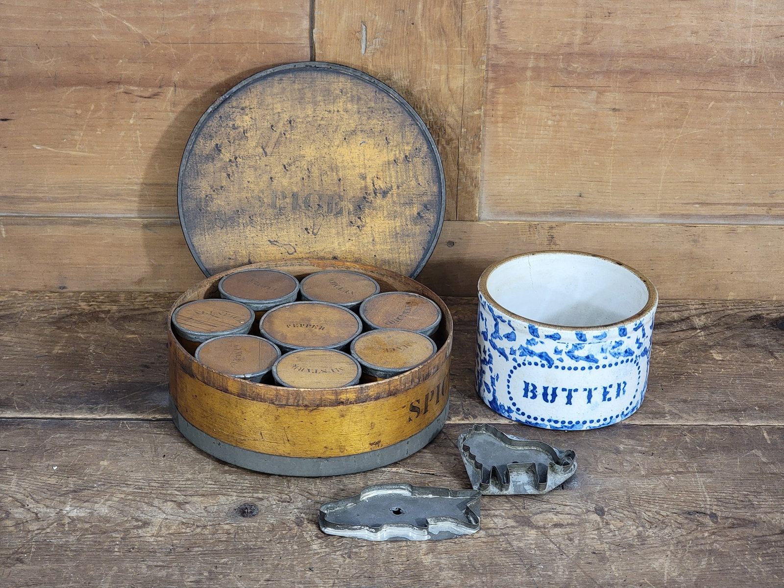 GROUP OF EARLY KITCHEN ITEMS: American, early 20th century. Includes a blue spongeware "BUTTER" crock, bentwood spice boxes with stenciled "SPICES" label and original spice canisters, and two tin cookie cutters in lion and fish fo