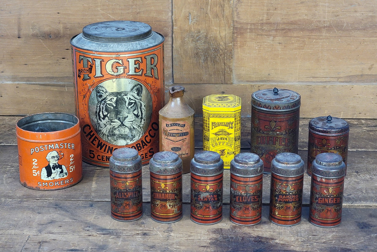 COLLECTION OF ADVERTISING ITEMS: Late 19th-early 20th century. Includes a stoneware whiting fluid bottle, a large Tiger tobacco tin, a Postmaster tobacco tin, a Franklin's Java Coffee tin, and a set of 8 tin spice canisters. Stonewar