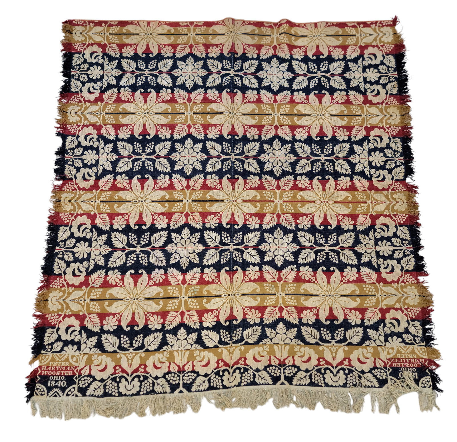 WOOSTER, OHIO COVERLET: Wayne County, Ohio, 1840. A two-piece coverlet woven in blue, red, and gold, a grapevine and floral border on three sides, a centerfield of grape and floral medallions, corner blocks "PETER / HARTMAN 