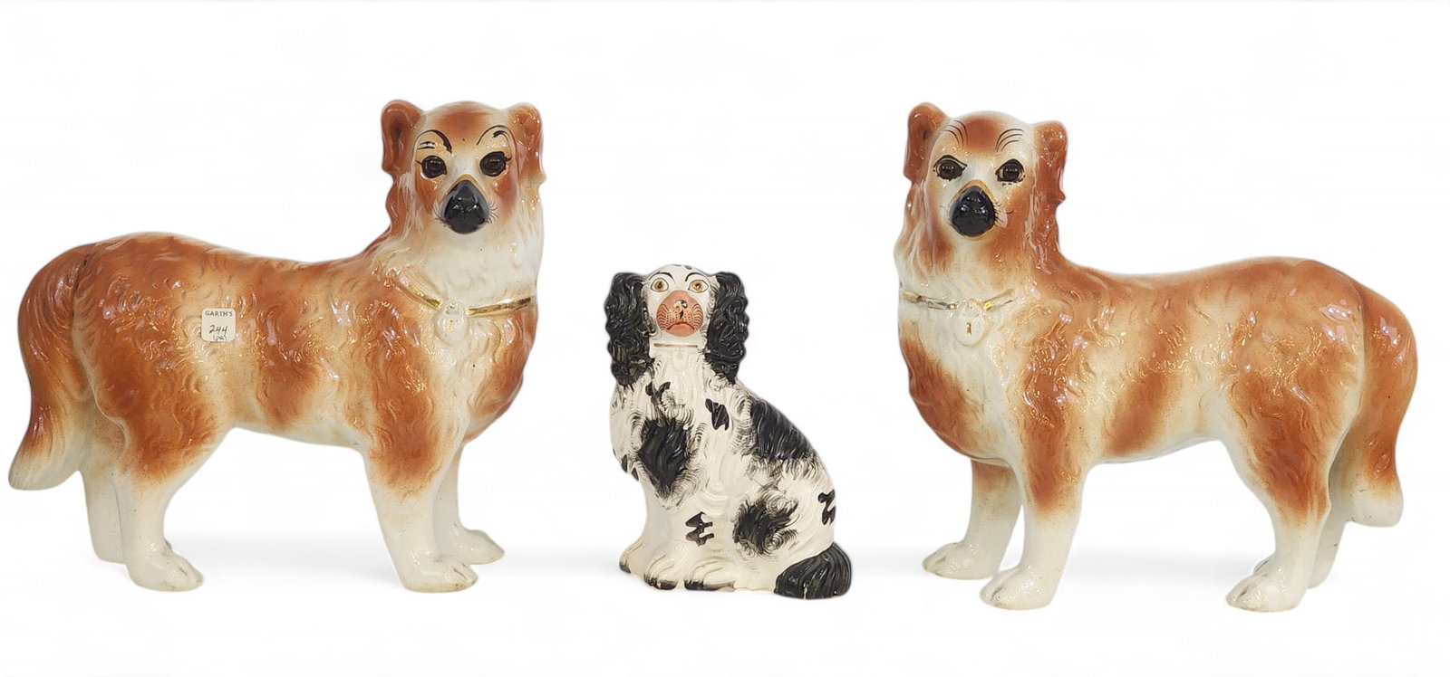 THREE STAFFORDSHIRE DOGS: English, late 19th century. Includes a pair of standing dogs in rust and white, and a single, seated, black and white spaniel, 11.5" and 7.5" high. Provenance: Kemp Collection, Belpre, Ohio. PLEASE NO