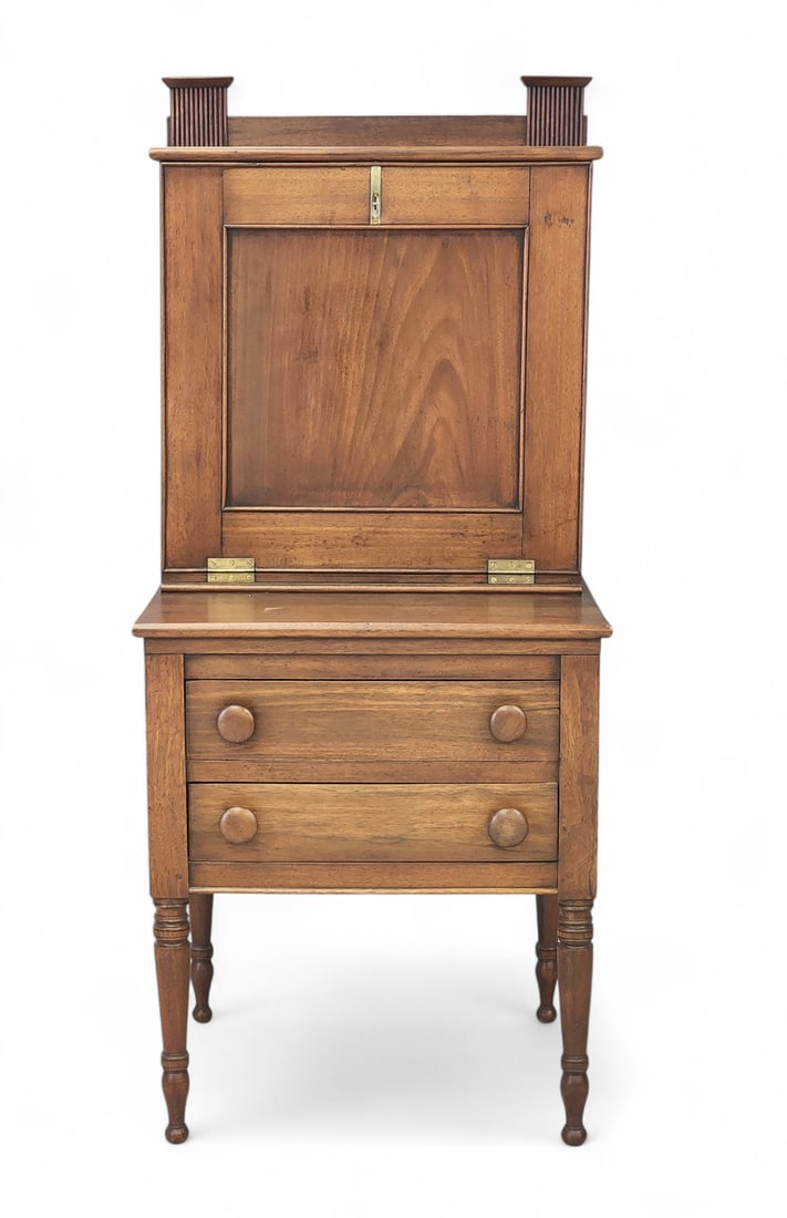 DIMINUTIVE SECRETARY: New Jersey, 1820-1840, walnut and poplar. Two-piece, the upper section with a fall front concealing cubbies and drawers; the lower section with two drawers and turned legs. One of the interior drawers