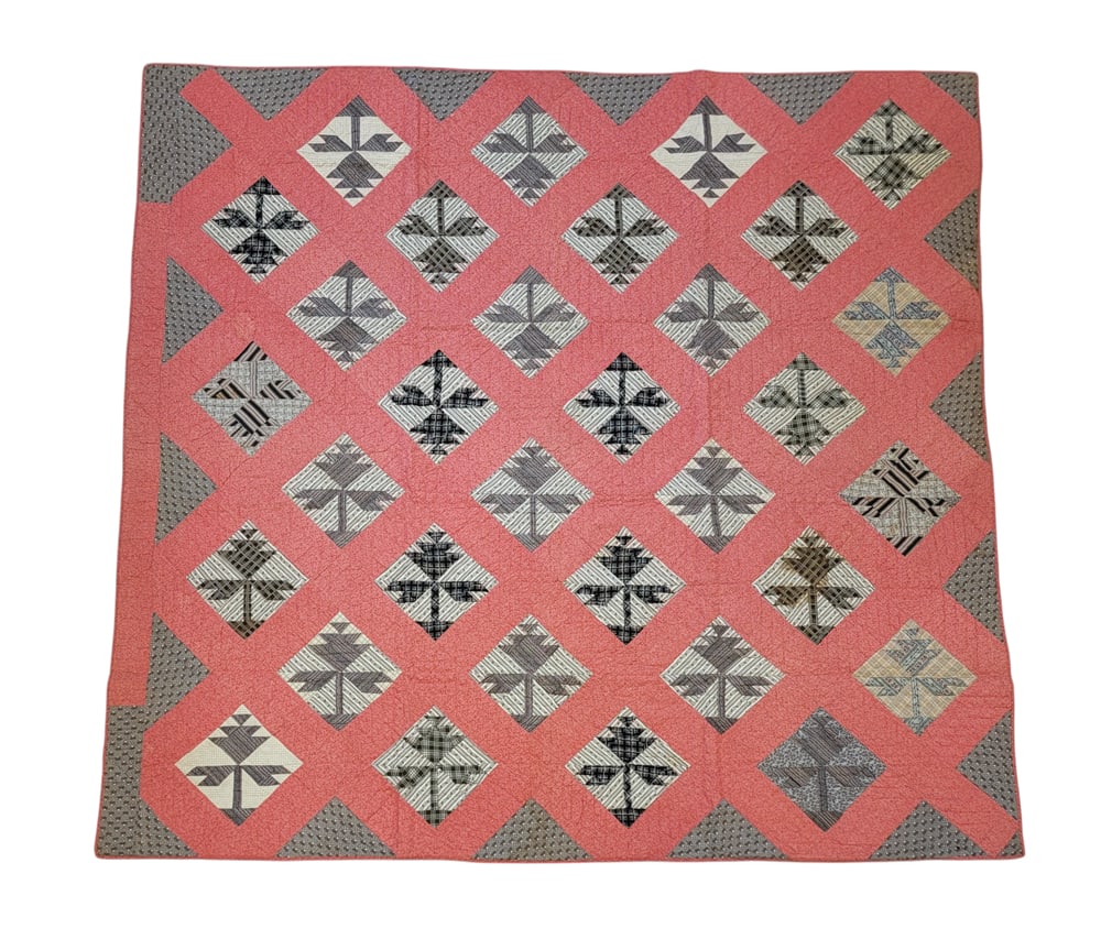 PIECED QUILT: American, 1884, cotton. A pieced quilt with thirty-two floral blocks in grey and black on a pink ground, pink binding, grey floral backing, 85" by 78". Provenance: The Virginia Gunn Collection, Wooste