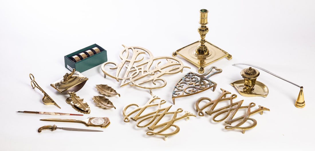 COLLECTION OF VIRGINIA METALCRAFTERS BRASS ITEMS: Williamsburg, miscellaneous group including trivets, desk accessories, a candlestick, and more. The stick is 7" high. Provenance: the collection of the late Jo Louise Brown, Zoar, Ohio. In-house shipp