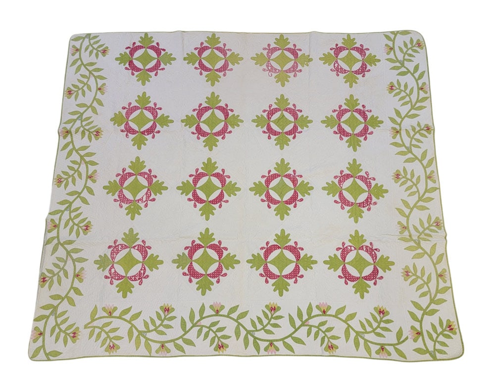 WAYNE COUNTY, OHIO OAK LEAF APPLIQUE QUILT: Ohio, mid-19th century, cotton. A handstitched quilt in solid green and red printed fabrics with sixteen oak leaf and reel appliques surrounded by three wide vining borders in green with flower buds i