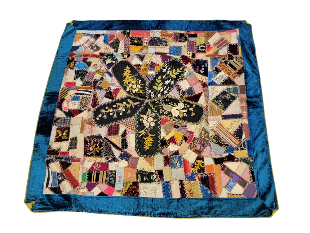 OHIO CENTENNIAL CRAZY QUILT: Ohio, 1888, cotton, silk, velvet. A pieced crazy quilt with a large five-armed shape in the center with floral embroidery on black, surrounded by various pieced designs in a variety of fabrics with co