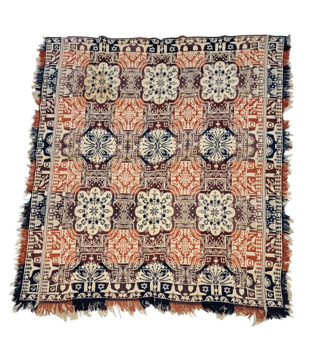 MASONIC JACQUARD COVERLET: American, mid-19th century. A coverlet in red, blue, and burgundy with a centerfield of floral medallions and vine designs, with double side borders and single head and foot borders, all with Masonic 