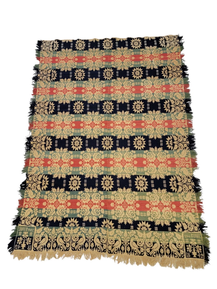 "ZUR RUHE" JACQUARD COVERLET: American, 1842. A coverlet in dark blue, green, and red with a primary motif of ornate roses and a secondary motif of sixteen-point star designs, with bird and rose borders, the corner blocks inscribe