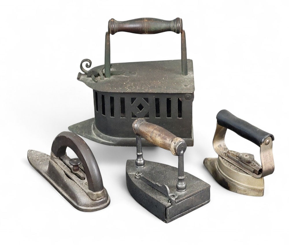 FOUR ANTIQUE IRONS: Late 19th-early 20th century. Largest is an early handmade charcoal iron, Normandy origin, with elaborated latch and cut work sides, 10" high, 10.5" wide, 6" deep; slug iron w/ slug and fixed handle 5