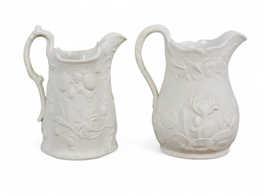 TWO BENNINGTON PARIAN PITCHERS: United States Pottery Company, Bennington, Vermont, mid-19th century. Molded Parian pitchers with a floral design. 8" and 8.5" high. Provenance: an Ohio collection. Affordable, in-house shipping is av