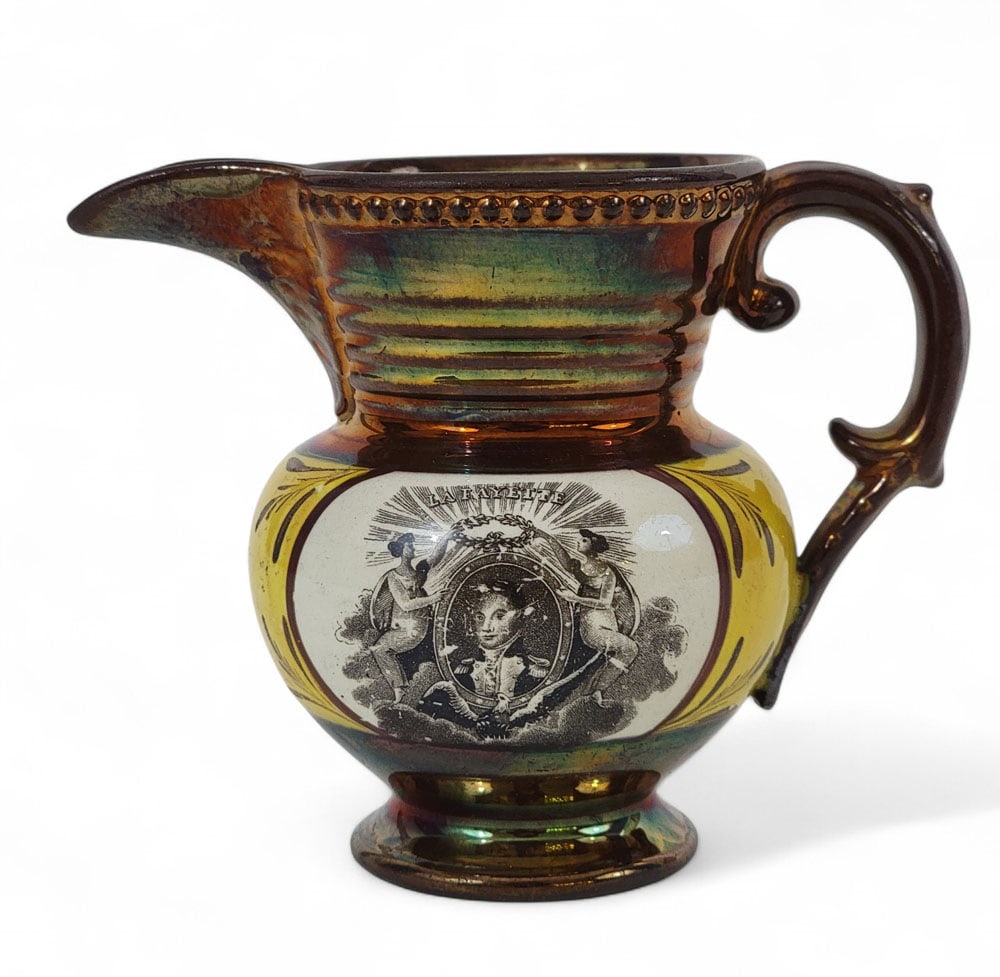 COPPER LUSTER LAFAYETTE & CORNWALLIS CREAM PITCHER: English, circa 1825, lusterware. Historical Staffordshire La Fayette copper luster creamer. One side displays a black-and-white transfer-printed portrait of La Fayette flanked by two angels holding a