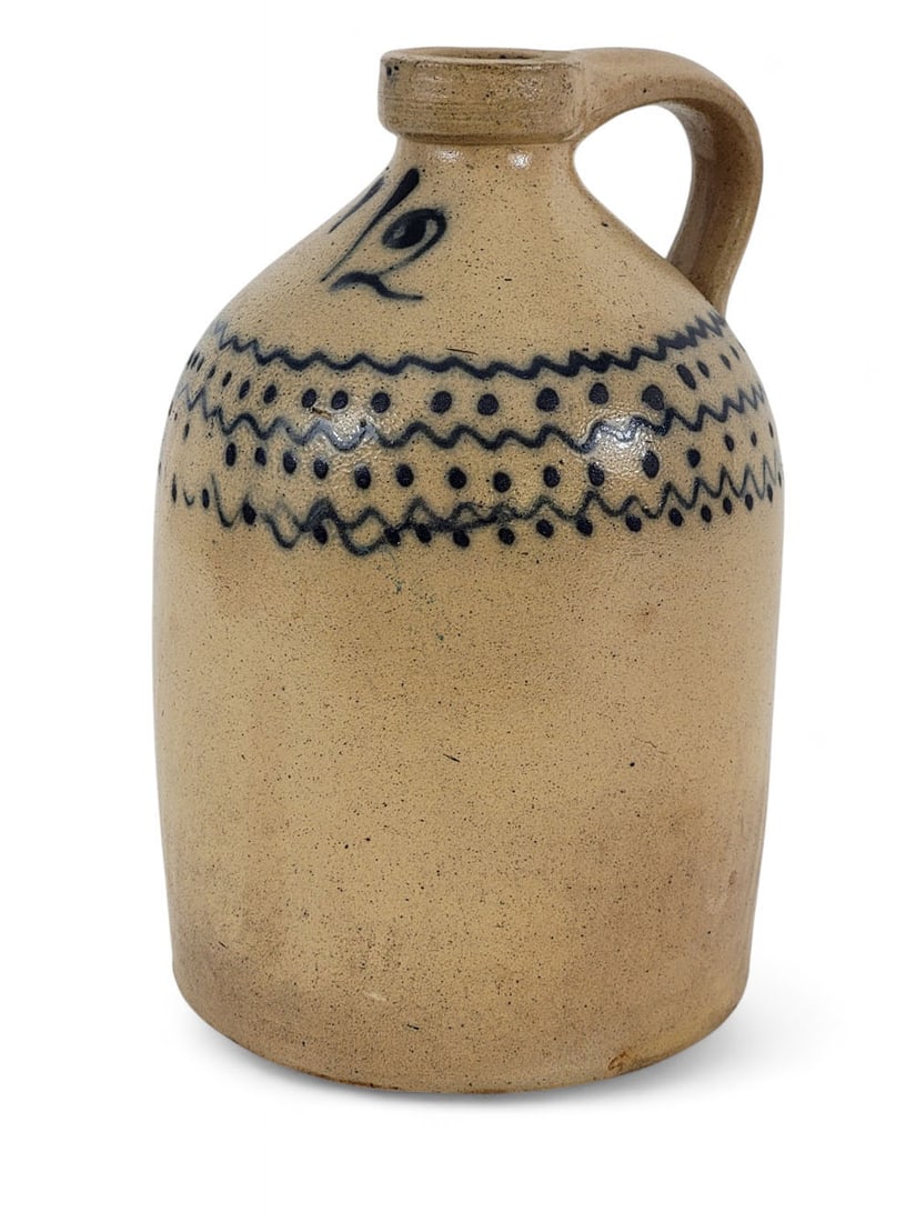 COBALT-DECORATED STONEWARE JUG: American, late 19th, stoneware. 1/2 gal cobalt decorated jug with wave-and-dot pattern around shoulder.Tooled lip, applied handle. 9" high. Provenance: from a Midwestern collection. Affordable, in-hou