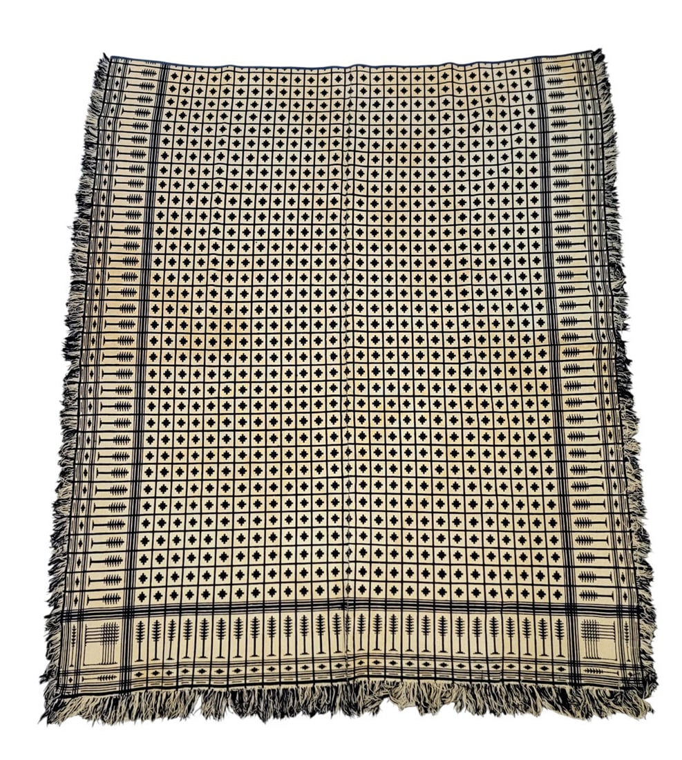 OVERSHOT COVERLET WITH PINE TREE BORDER: American, 19th century, wool and linen. Jacquard coverlet in navy and white, with pine tree border and small geometric pattern in center. Hand-woven in two pieces, united in middle. Fringed with blue