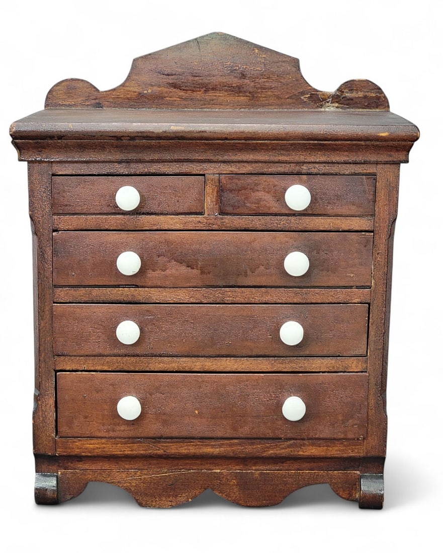 MINIATURE BLANKET CHEST: American, mid-19th century, cherry. Two over three drawers, with a shaped backsplash and base, and scrolled front feet. 17" high, 13.5" wide, 8.25" deep. Provenance: a Midwestern collector Affordable,