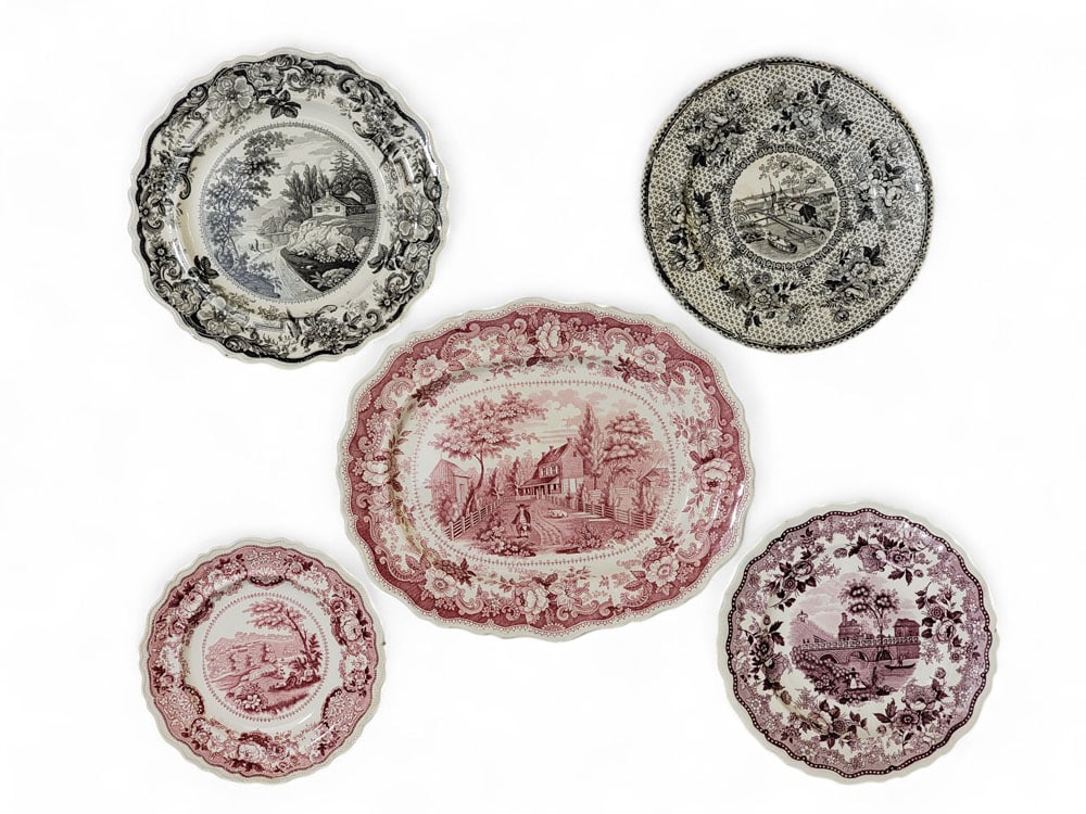 FIVE STAFFORDSHIRE AMERICAN HISTORICAL VIEWS: English, 19th century. Includes a red Residence of the late Richard Jordan, New Jersey platter, 13.5" long; a black Erie Canal at Buffalo plate, 9.5" diameter; a mulberry Race Bridge Philadelphia plat