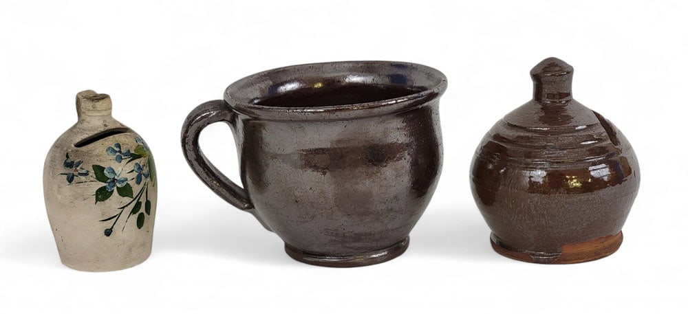 THREE PIECES OF MINIATURE POTTERY: American, 19th century. Includes a redware porringer, redware bank, and buff-colored bank with floral decoration. 3.25" to 3.5" high. Provenance: an Ohio collection. Affordable, in-house shipping is a