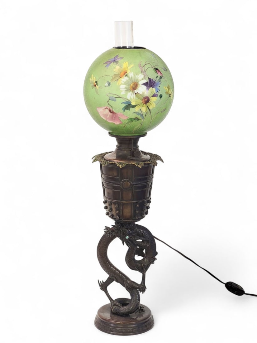 BRONZE DRAGON LAMP WITH GREEN BALL SHADE: American, early 20th century. Bronze electrified oil lamp with coiled dragon supporting chinese-style font, crown ring, and green ball shade with handpainted flowers. 35" high. Provenance: a southeast