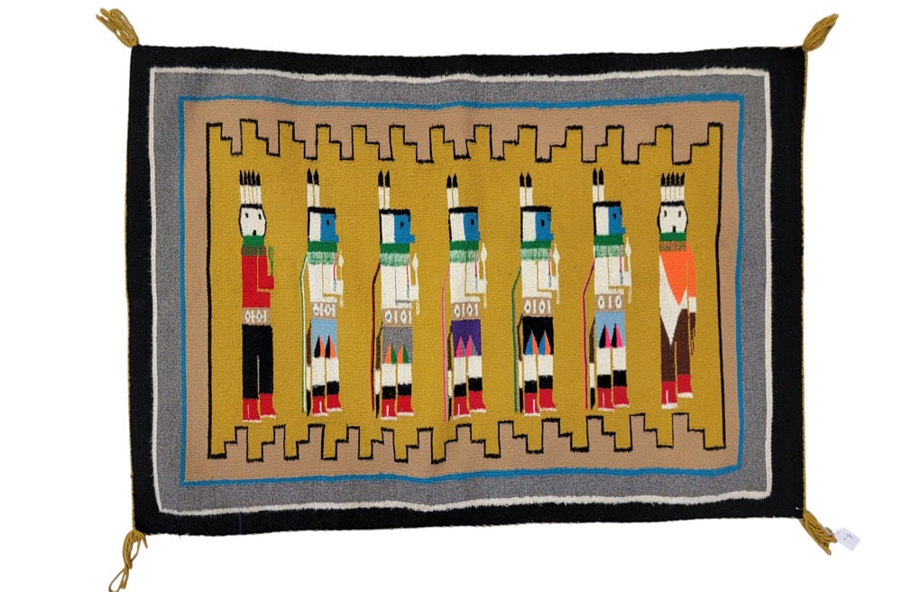 NAVAJO YEI RUG: 1930-1950, wool. Seven figures against a mustard ground. 32" by 46". Provenance: a Midwestern collector Affordable, in-house shipping is available for this lot. Please contact us for a quote.