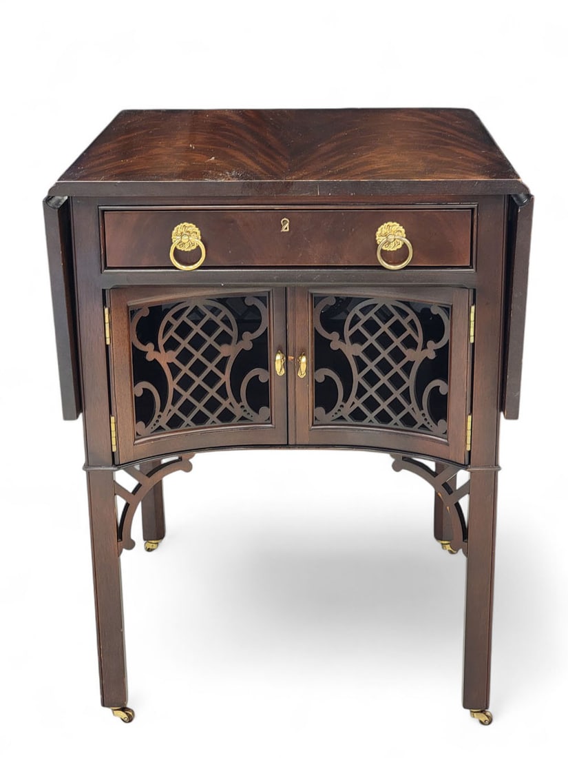 CHINESE CHIPPENDALE-STYLE MAHOGANY SIDE TABLE: 20th century, after a design for a breakfast table by Thomas Chippendale. Highly polished crotch mahogany with drop leaves and butterfly supports on either side. Front has shallow drawer with two gilt