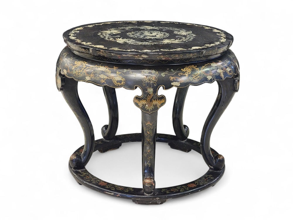 MOTHER-OF-PEARL INLAID CHINESE TABLE: Chinese, 20th century. Black lacquer drum table with Mother-of-Pearl inlaid top featuring a dragon, phoenixes, clouds, and flowers. Sides, five legs, and base painted with more of the same in many col