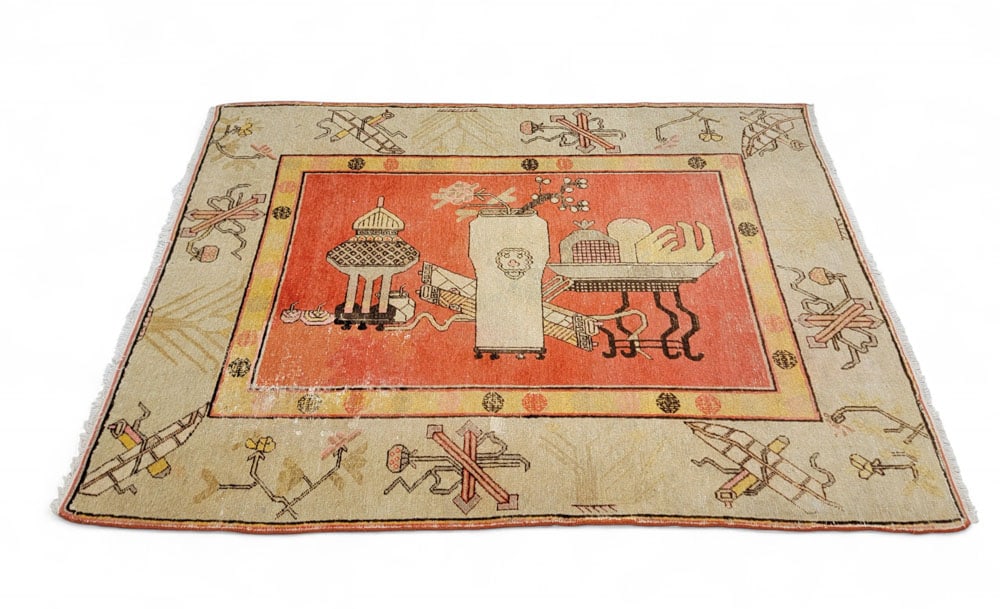 PICTORAL KHOTAN RUG: Turkish, 1st half-20th century. Reddish orange base with yellow and cream colored borders. Pictoral image in center with figures spaced throughout border. 79" by 57". From a Columbus, Ohio collection.