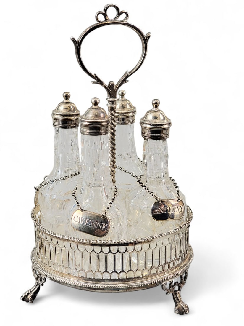 GEORGE III SILVER CRUET SET: Worn marks, possibly John Dawell and John Marshall, London, 1770, tags possibly John Robins, 1803. Four silver-mounted and cut-glass bottles with labels for popular Georgian table seasonings: Cayenne,