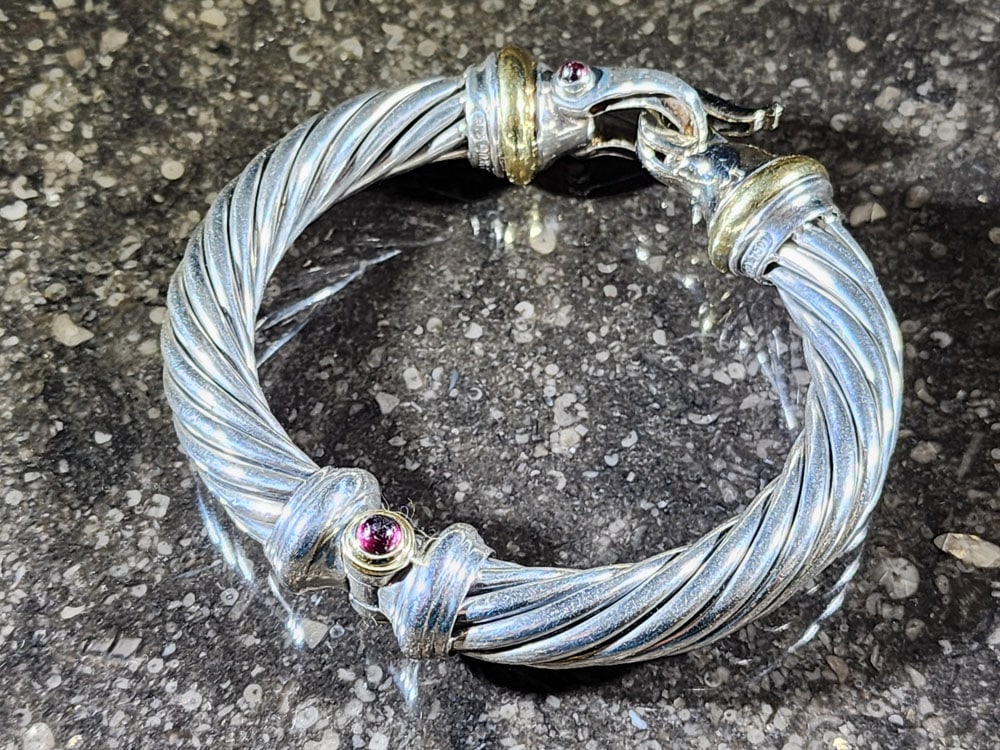 DAVID YURMAN CABLE BRACELET: Marked. 18K gold and sterling silver, with diamonds and garnets. 55g. Provenance: a Columbus, Ohio collection. Affordable, in-house shipping is available for this lot. Please contact us for a quote.