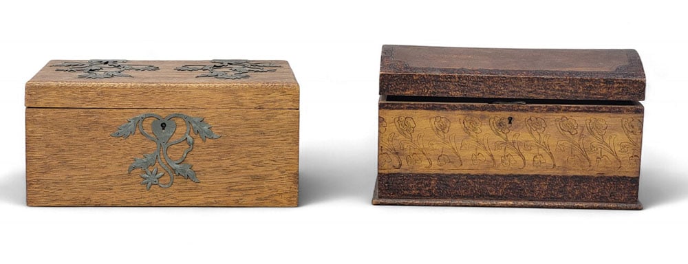 TWO WOODEN BOXES: Early 20th century, mixed woods. Two decorative boxes. An oak box with flat lid and elaborate decorative metal hinges and escutcheon shaped like leaves and flowers. 5" high, 10.75" wide, 8" deep. And