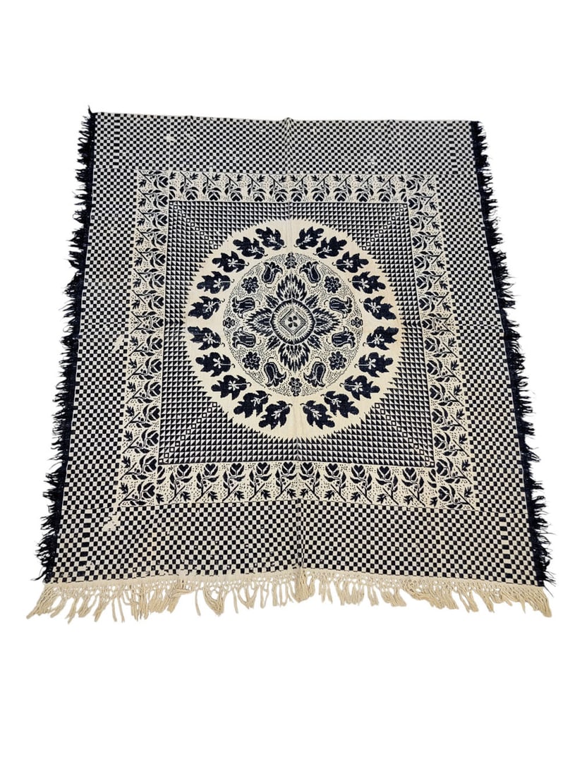 JACQUARD COVERLET: American, mid-19th century, wool and linen. A blue and white checkerboard jacquard coverlet with central medallion featuring tulips and oak leaves, and a thick border of flowers with heart buds. Fring