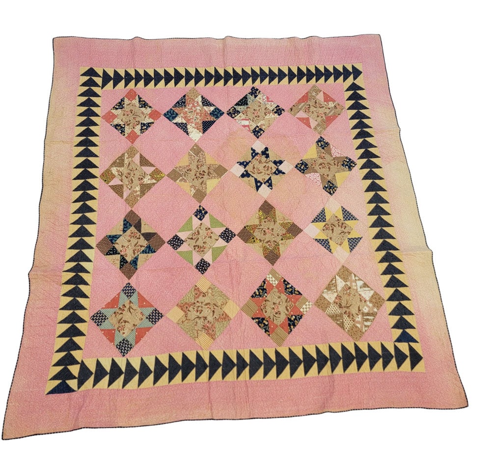 OHIO STAR QUILT WITH FLYING GEESE BORDER: American, 19th century, cotton. A patchwork Ohio star quilt with stars set in square/diamond blocks and a Flying Geese border. Composed of brown, blue, yellow, green, and pink printed fabrics on a pin