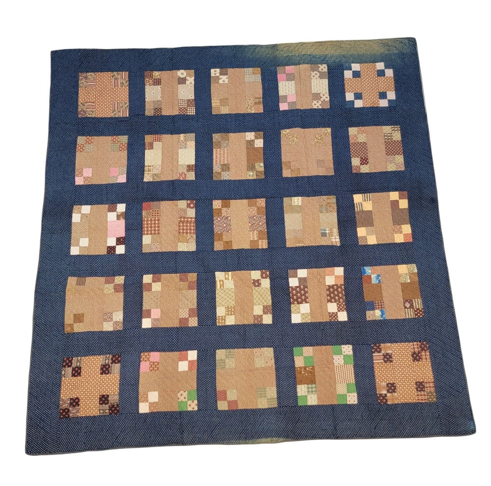 MODIFIED NINE-PATCH QUILT: American, 19th century, cotton. A latticed nine-patch variation with four-square pieces. Composed of brown, pink, red, and green printed fabrics on a blue printed ground. Hand-pieced and quilted. 79"