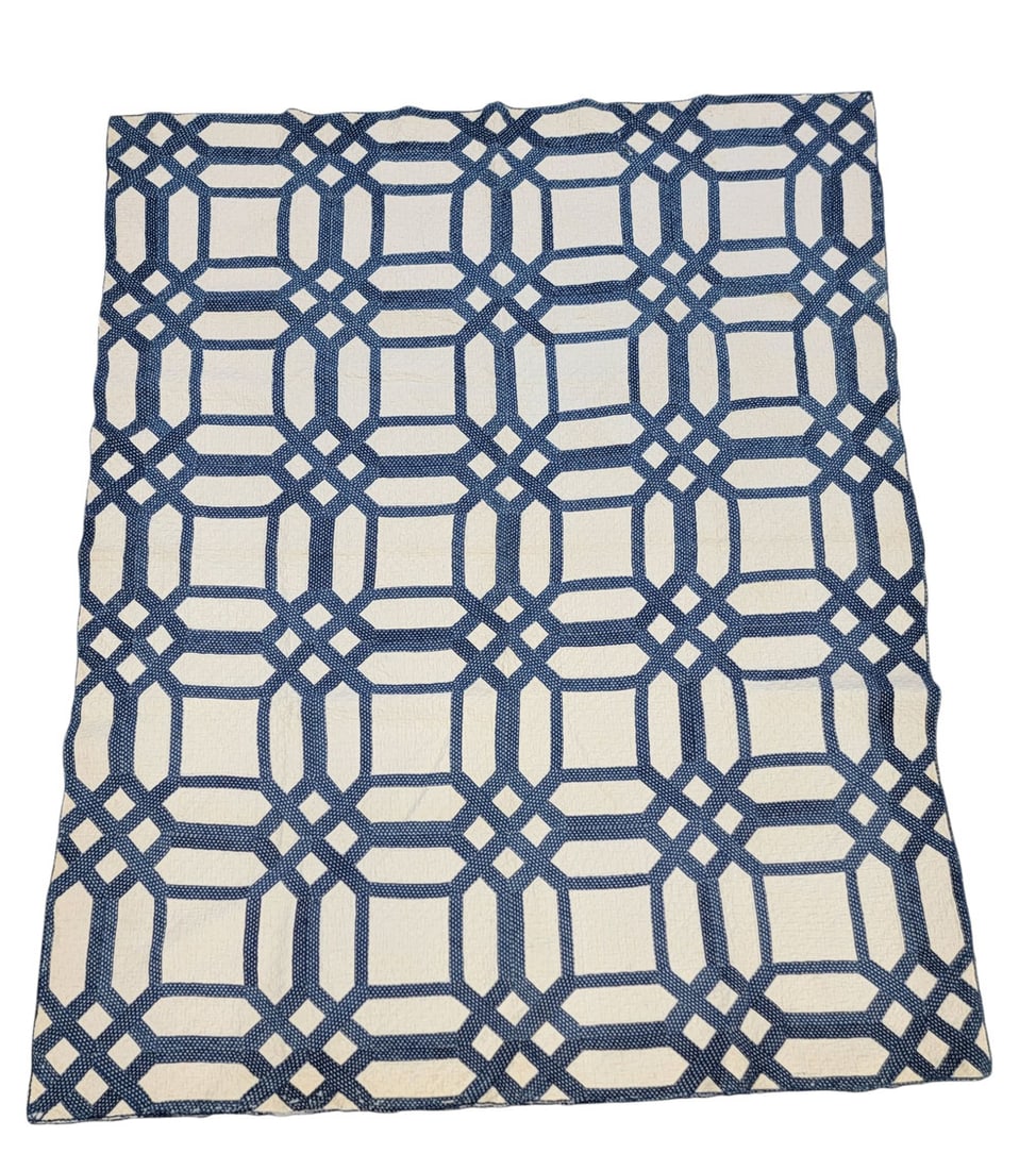 BLUE AND WHITE OCTAGON PATCHWORK QUILT: American, 19th century, cotton. A patchwork quilt composed of blue printed interlacing octagons on solid white ground. Hand-pieced and quilted. 87" long, 70" wide. Provenance: The Collection of the la