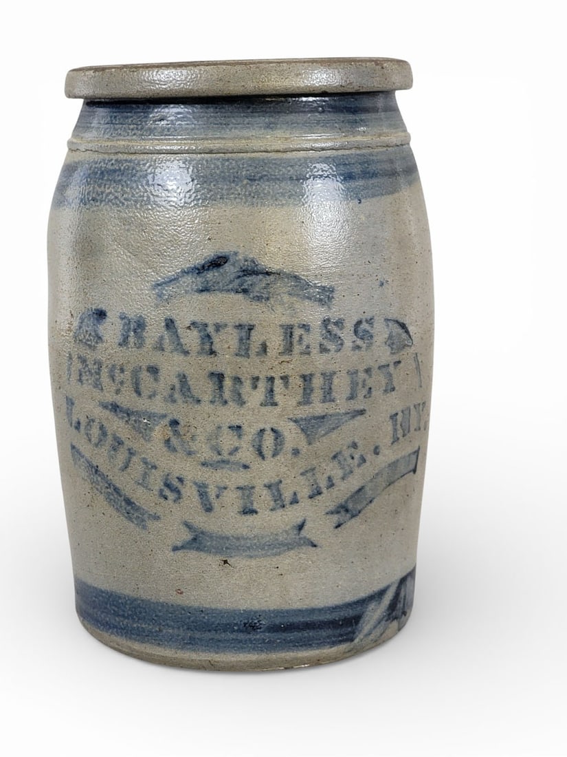 DECORATED KENTUCKY STONEWARE JAR: Southwestern Pennsylvania, c. 1875, retailed by Bayless, McCarthey & Co., Louisville. One-gallon jar with cobalt stenciled decoration, including stripes, 10" high. Provenance: the collection of the la