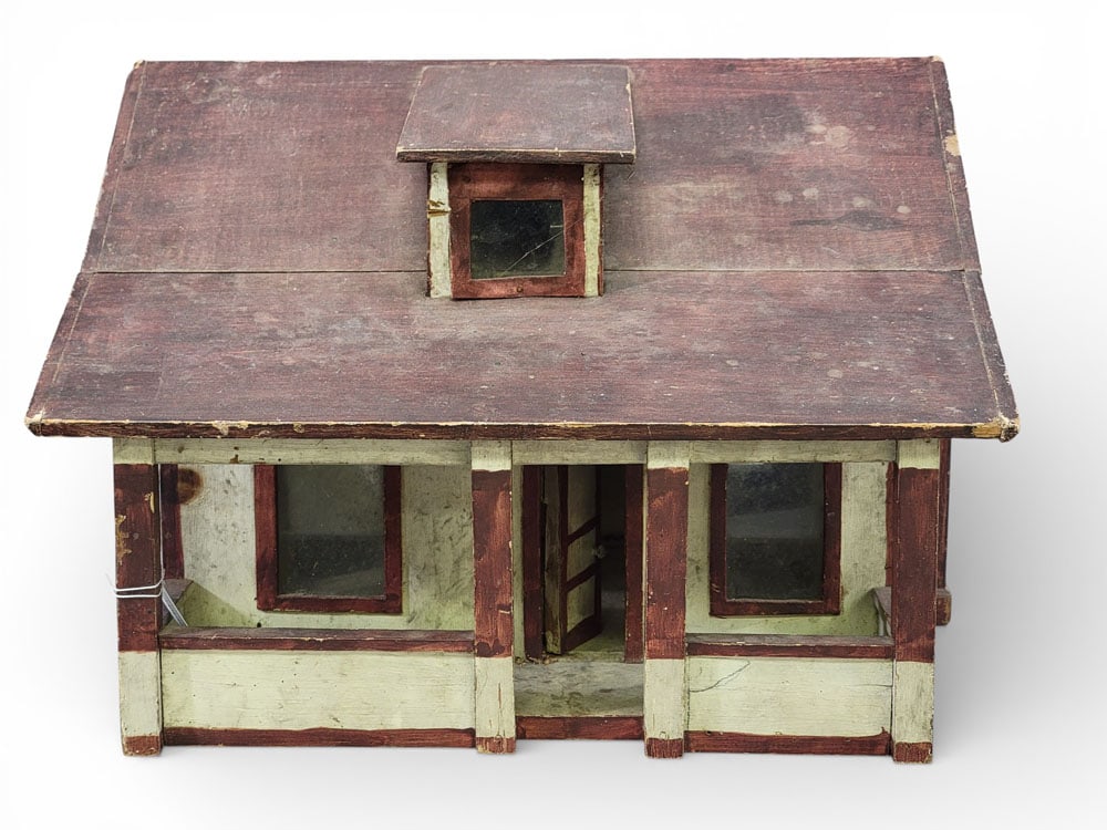 MODEL HOUSE: American, early 20th century, mixed woods. Small model of home with dormer window and columned porch. Retains its original red and white paint. 10.5" high, 15.25" wide, 14" deep. Provenance: an Ohio c