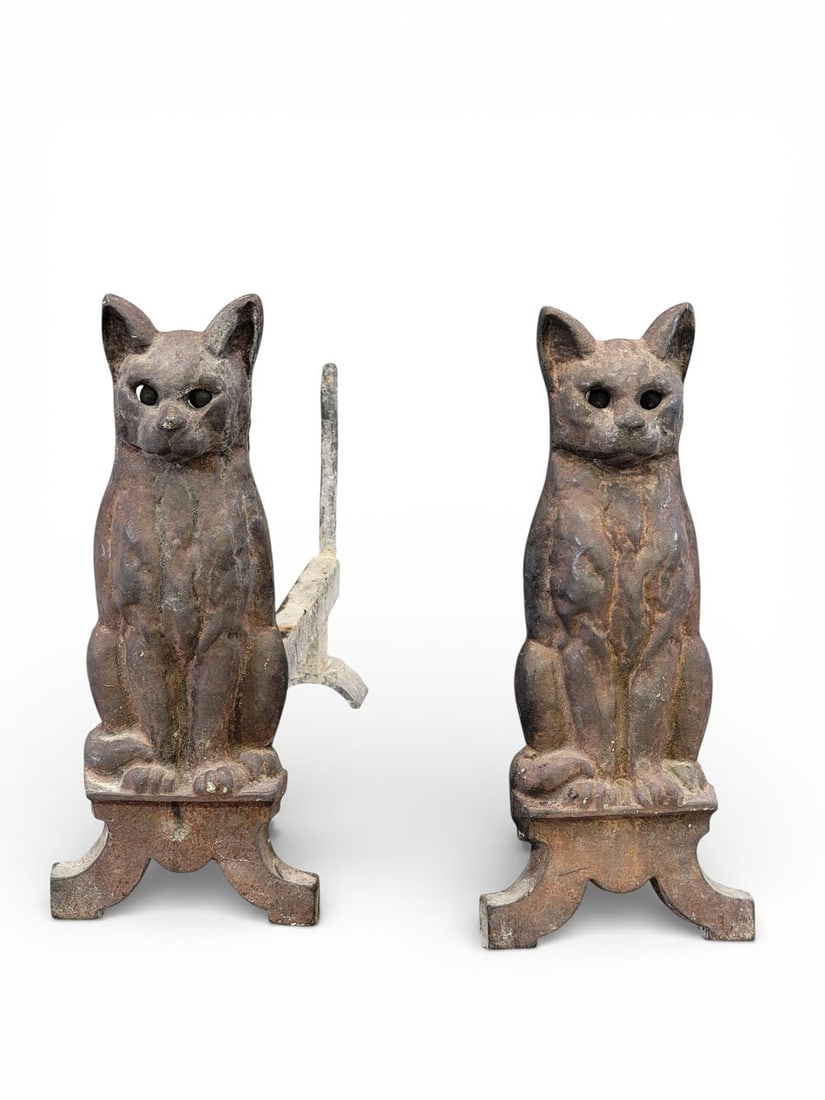 PAIR OF CAT ANDIRONS: American, early 20th century, cast iron. Seated cat figures with green marble eyes that glow when the fire is lit. 16" high, log bars are 20" long. Provenance: an Ohio collection. NOTE: We are happy t