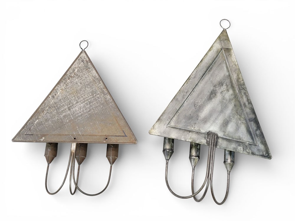 NEAR-PAIR OF TIN SCONCES: American, 19th-20th century. Two three-light sconces with triangular sheet-metal reflectors. Larger 16.5" high, 10.75" wide. Provenance: a Pennsylvania collection. NOTE: We are happy to answer questio