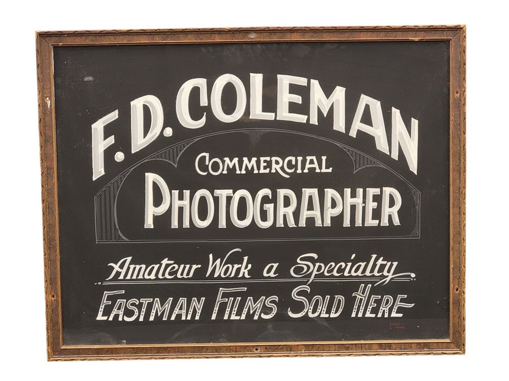 NEW YORK STATE PHOTOGRAPHER'S TRADE SIGN: Cooperstown, c. 1935, paint on heavy cardstock. "F.D. COLEMAN COMMERCIAL PHOTOGRAPHER Amateur work a Specialty EASTMAN FILMS SOLD HERE." Signed lower right "Garland Cooperstown." Framed, 21.75" high, 