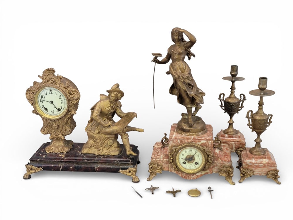 PAIR OF VICTORIAN FIGURAL MANTEL CLOCKS: Late 19th and early 20th centuries, spelter, glass, marble, wood. A Moreau mantel set and a W. L. Gilbert clock with figural accents. Moreau mantel set includes a pair of urn-form candlesticks and a c