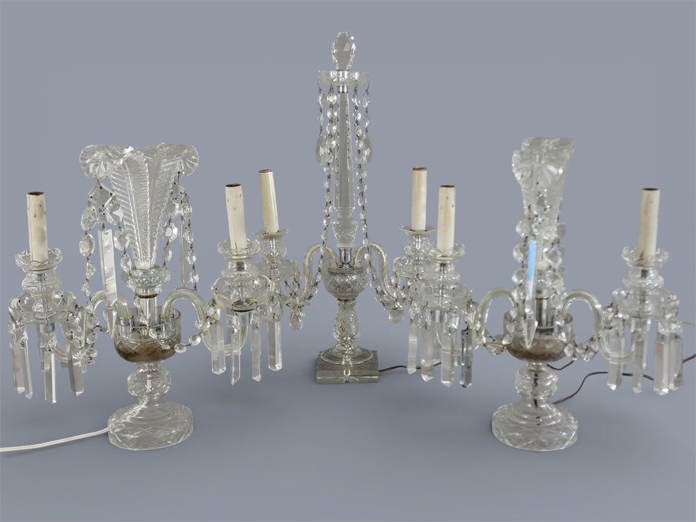 THREE CRYSTAL TWO-LIGHT ELECTRIC CANDELABRAS: American, early 20th century, cut glass. Three crystal two-light electric candelabras. A pair with Prince of Wales feathers, and another with a 'spire' and cut finial. Both with cut prisms around cups