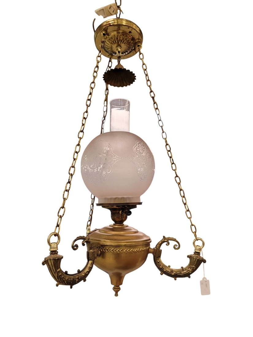 NEOCLASSICAL ELECTRIFIED KEROSENE CHANDELIER: American, 19th century, brass and glass. A Neoclassical electrified kerosene chandelier with three scrolled arms supporting the chains, a tapered font, and a frosted glass globe etched with Classical